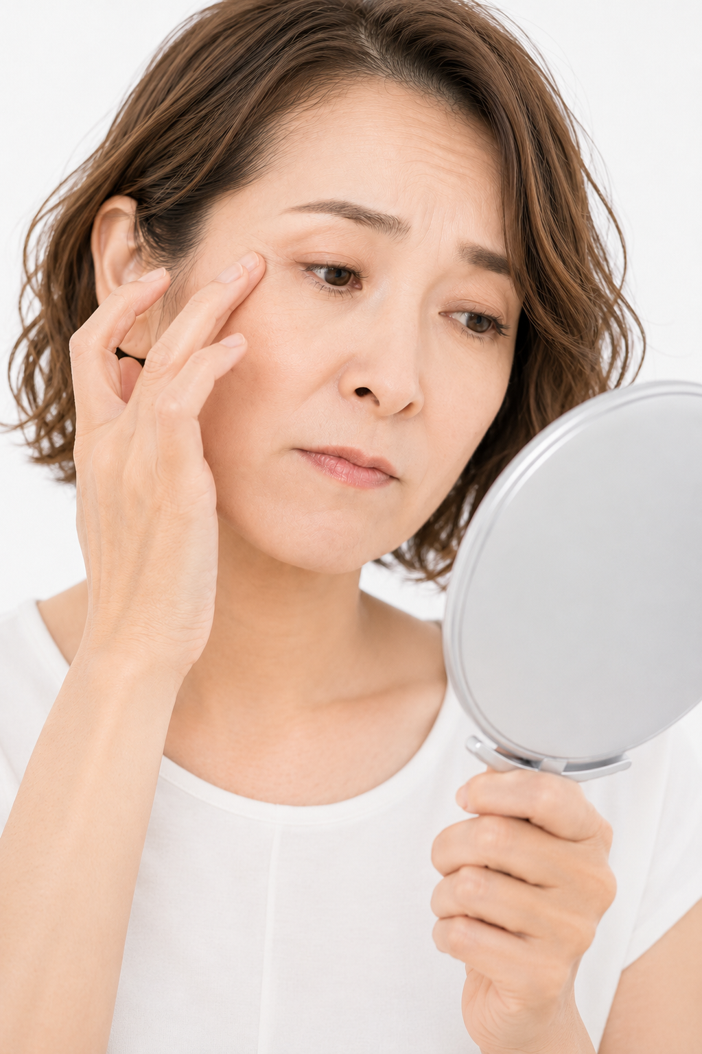 鏡を見て肌の変化を気にする40代の女性